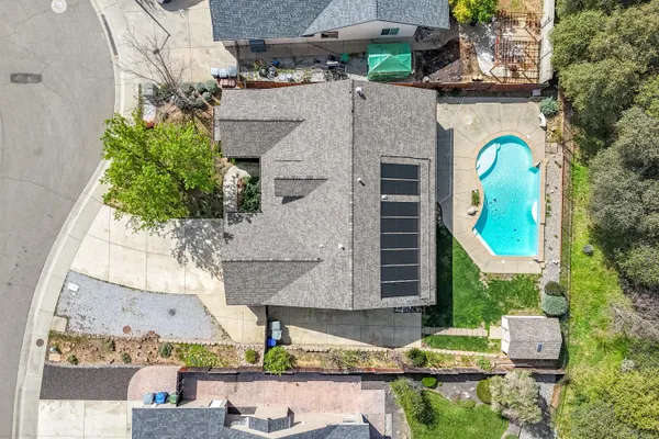 an aerial view of residential house with outdoor space and trees all around
