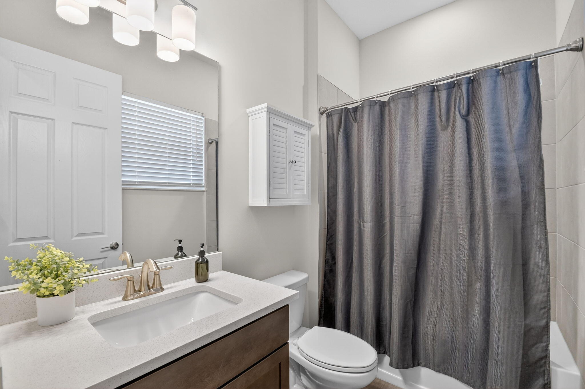 1055 Ember Ridge Run Loxahatchee, FL 33470 - Photo 37 of 103 a bathroom with a sink a toilet and shower curtain
