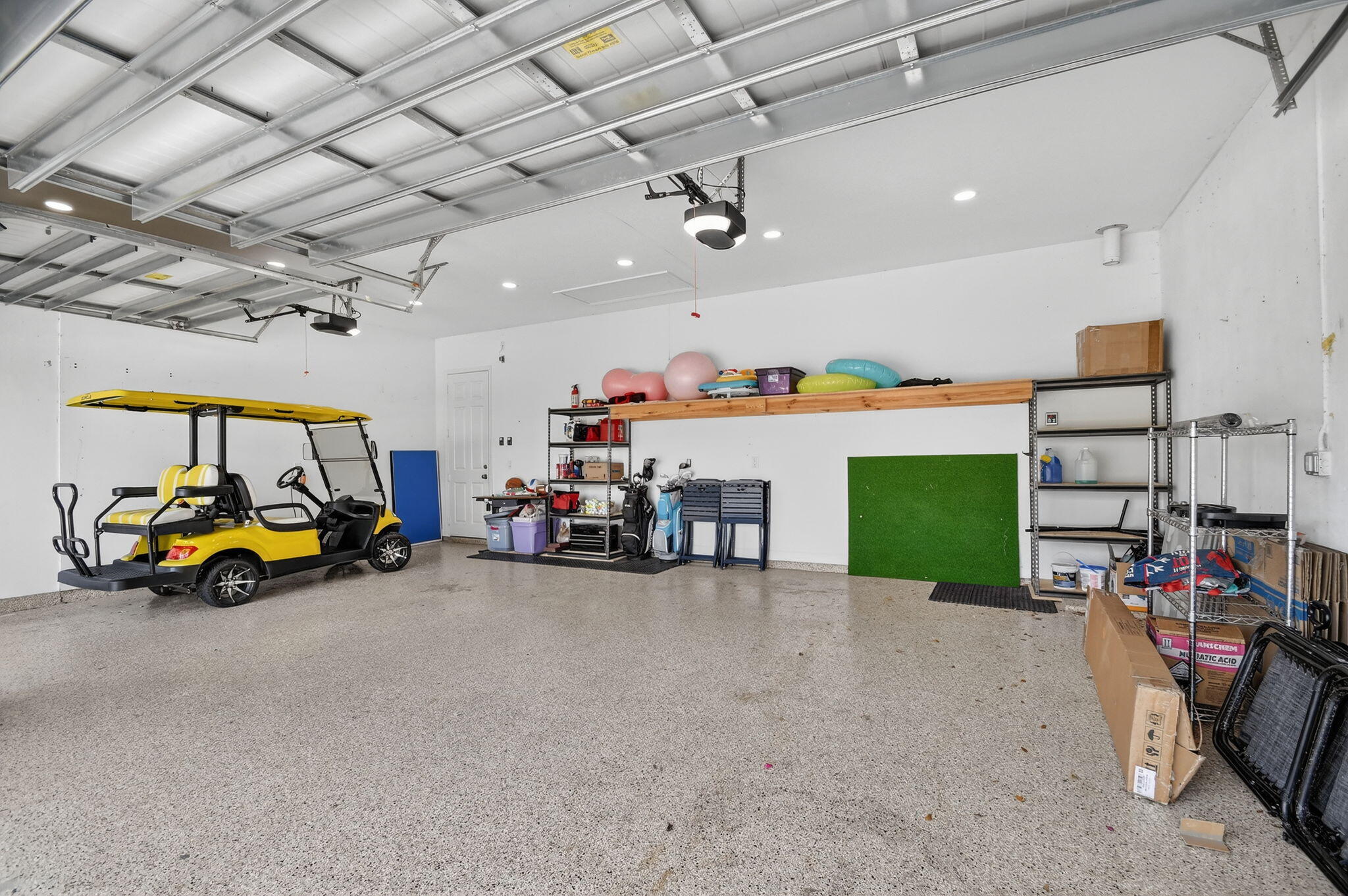 1055 Ember Ridge Run Loxahatchee, FL 33470 - Photo 58 of 103 a view of a garage with a flat screen tv and a table