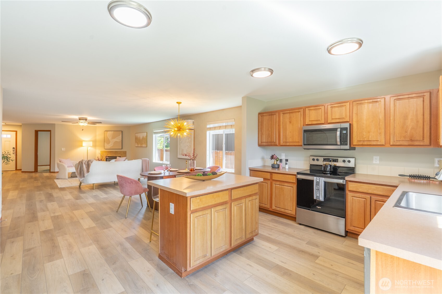 242 Riggs Drive East Enumclaw, WA 98022 - Photo 15 of 40 a open kitchen with stainless steel appliances granite countertop a stove top oven a sink dishwasher and white cabinets with wooden floor