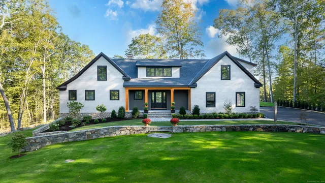 a front view of a house with a yard and outdoor seating
