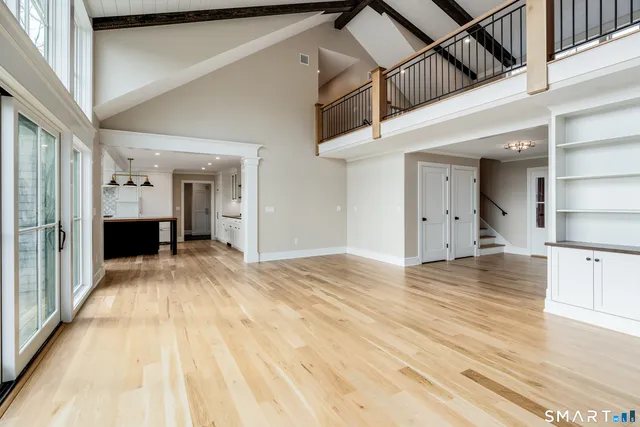 a kitchen with stainless steel appliances cabinets wooden floor and a window