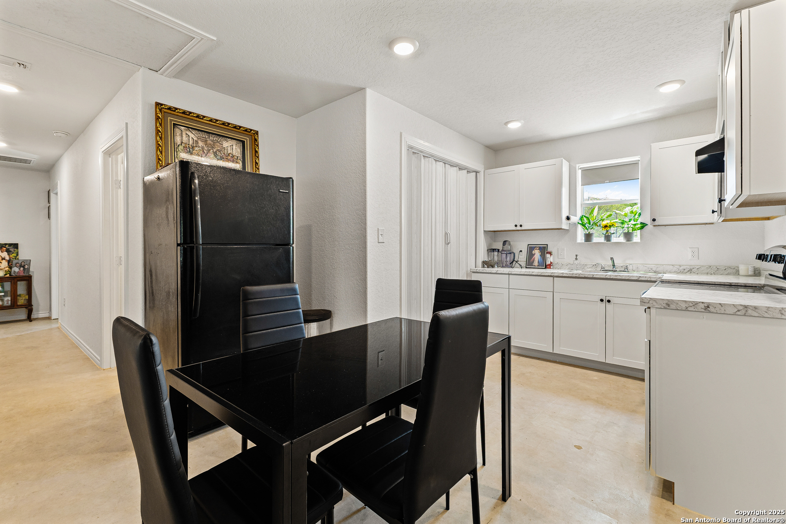 128 County Road 2672 Devine, TX 78016 - Photo 16 of 44 a kitchen with a table chairs refrigerator and microwave