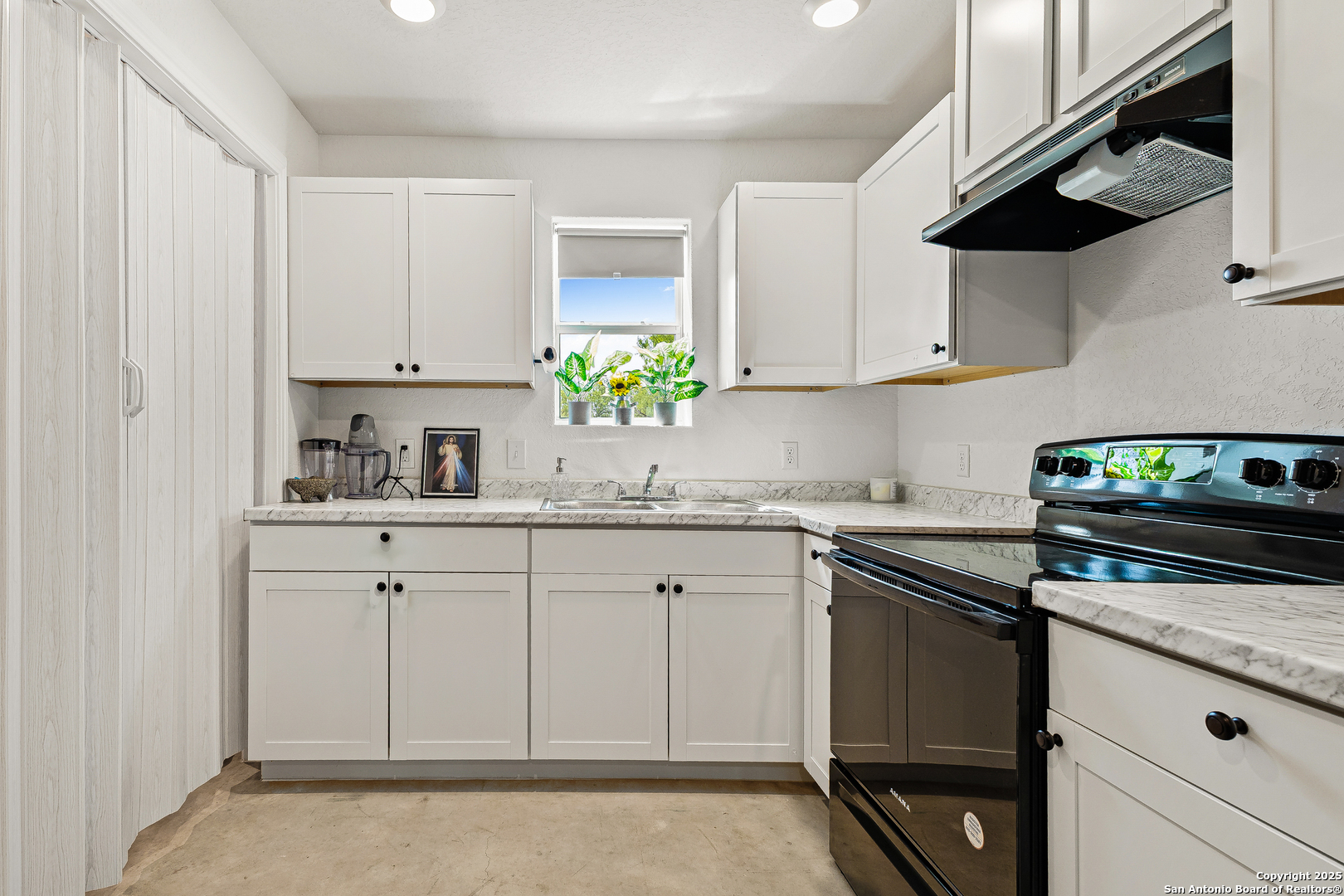 128 County Road 2672 Devine, TX 78016 - Photo 18 of 44 a kitchen with granite countertop white cabinets and white appliances