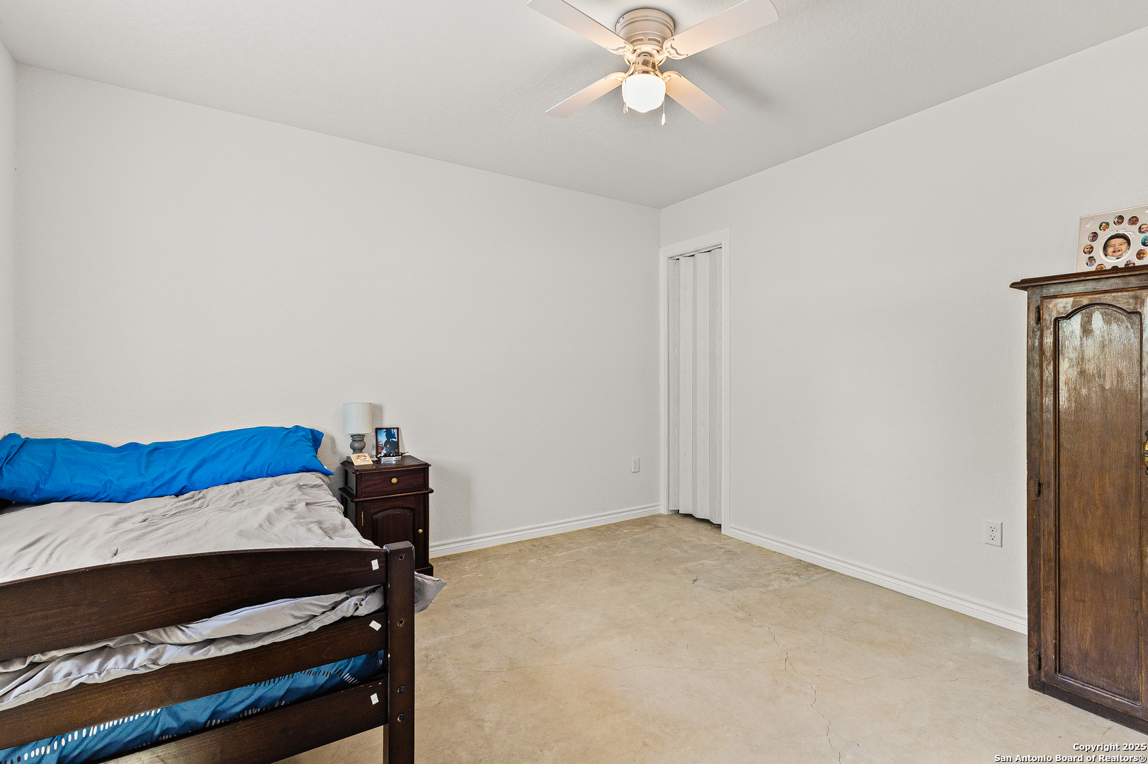 128 County Road 2672 Devine, TX 78016 - Photo 20 of 44 a bedroom with a bed and a chandelier