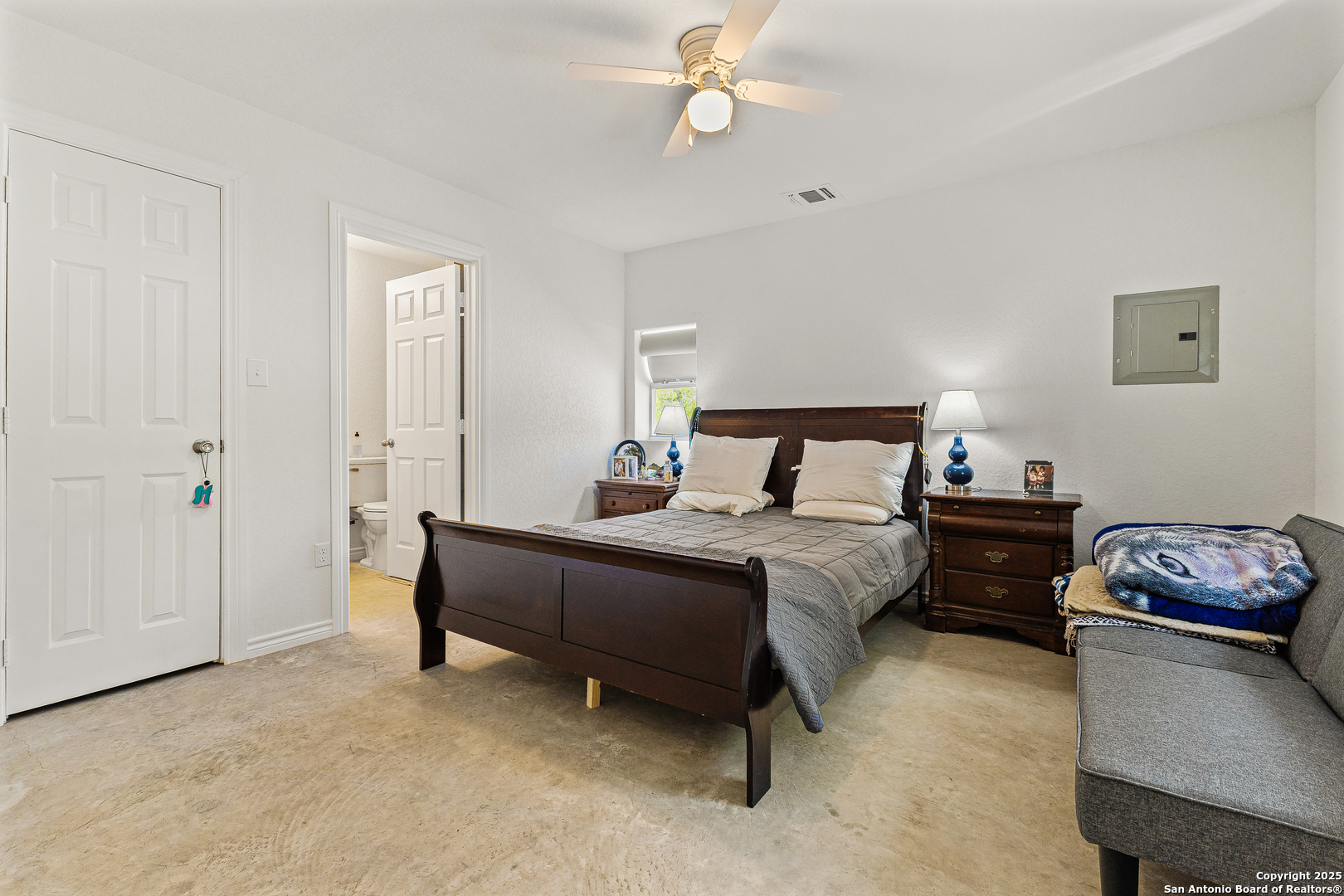 128 County Road 2672 Devine, TX 78016 - Photo 22 of 44 a bedroom with a bed and a chandelier