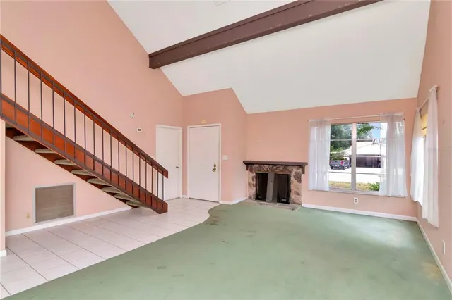 a view of a livingroom with fireplace stairs and windows