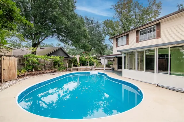 a view of a patio with table and chairs potted plants and large tree