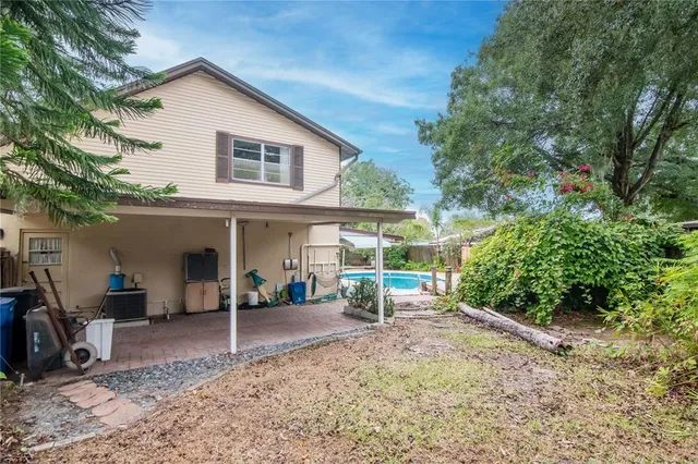 a backyard of a house with plants and outdoor seating