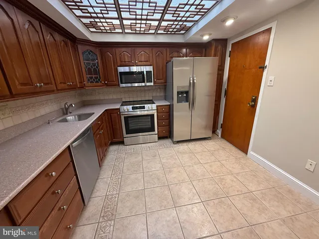 a kitchen with stainless steel appliances granite countertop wooden cabinets a stove top oven a sink and dishwasher
