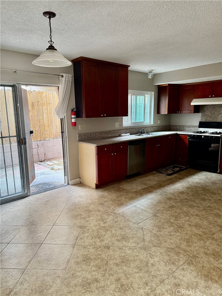 264 West Jackson Street Rialto, CA 92376 - Photo 17 of 32 a kitchen with stainless steel appliances granite countertop a stove a sink and a refrigerator