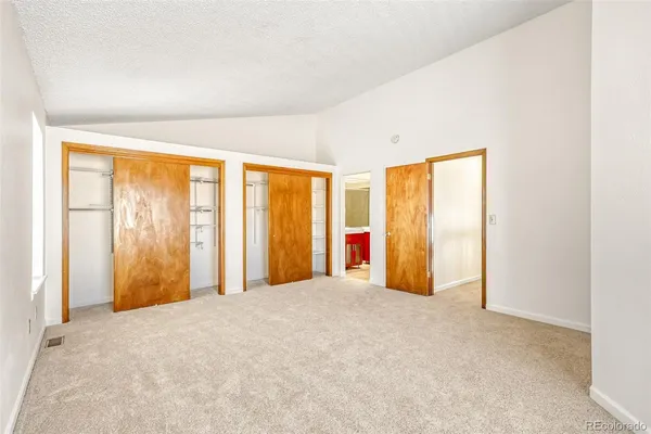 an empty room with windows and closet