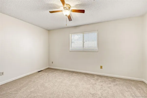 an empty room with closet and a chandelier fan