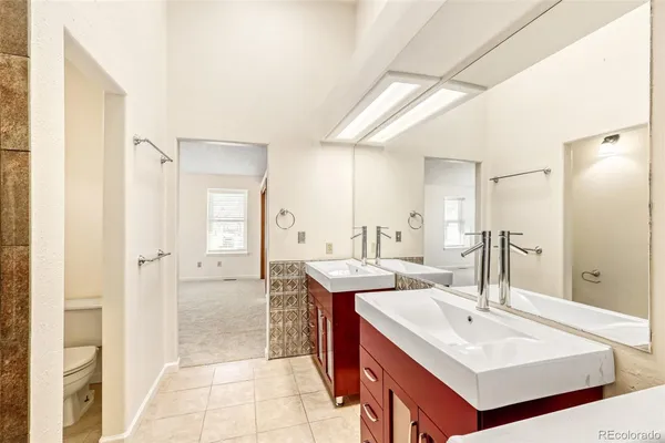 a bathroom with a sink a toilet a mirror a bathtub and shower