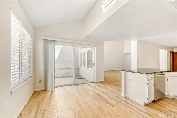 a view of a kitchen with wooden floor and a window