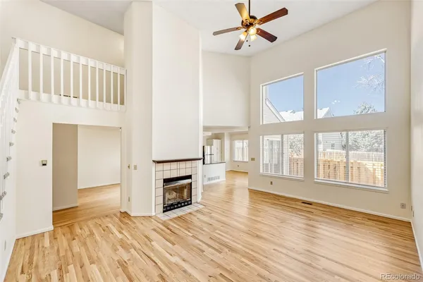 wooden floor fireplace and windows in an empty room