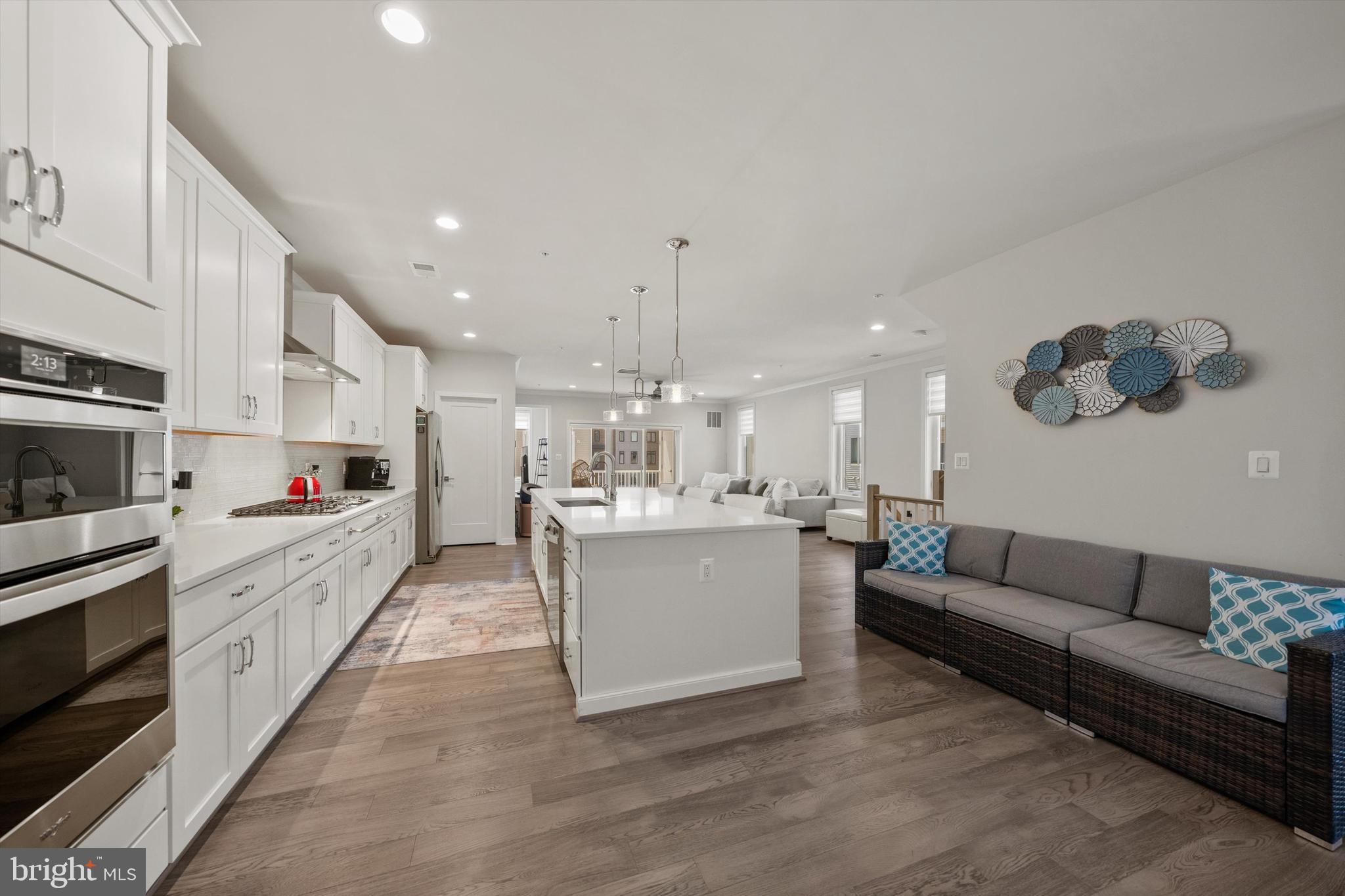43179 Mongold Square Ashburn, VA 20148 - Photo 11 of 46 a large white kitchen with stainless steel appliances granite countertop a stove oven a sink dishwasher and white cabinets with wooden floor