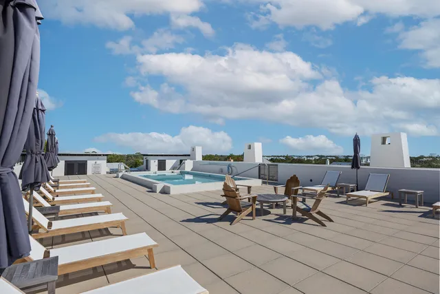 a view of a patio with lawn chairs
