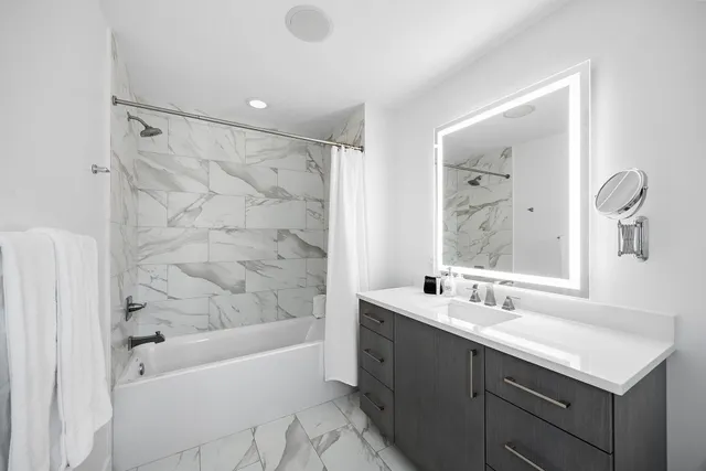 a bathroom with a sink a toilet a mirror and shower