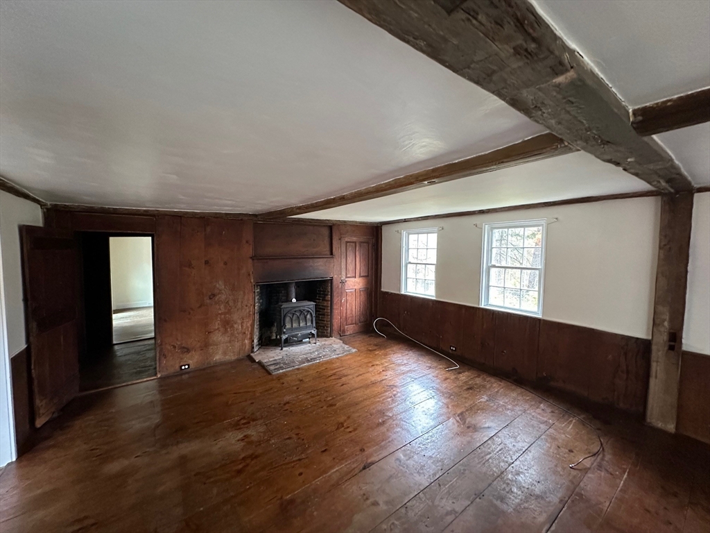 333 Dedham Street Dover, MA 02030 - Photo 11 of 24 an empty room with wooden floor and fireplace