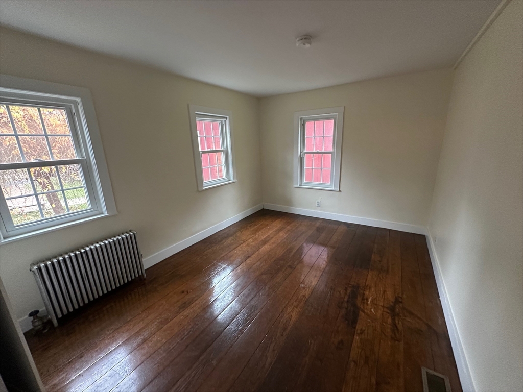 333 Dedham Street Dover, MA 02030 - Photo 19 of 24 an empty room with wooden floor and windows