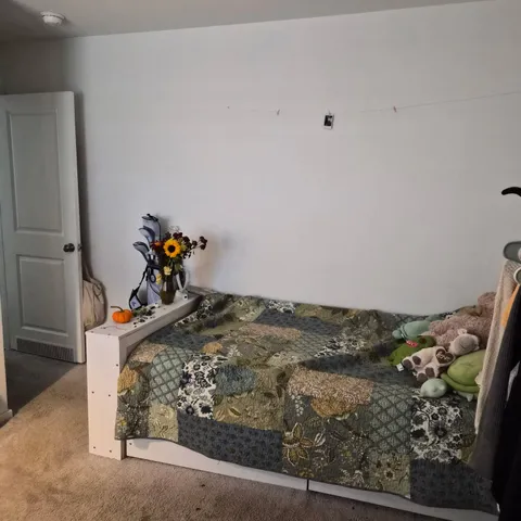 a bed sitting in a bedroom next to a window