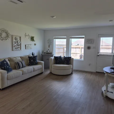 a living room with furniture and a wooden floor