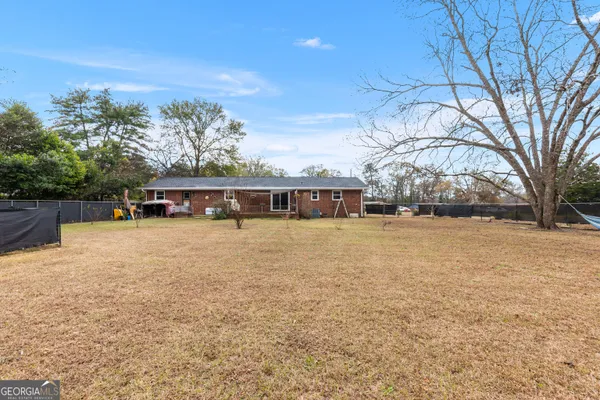 a front view of house with yard and trees in the background
