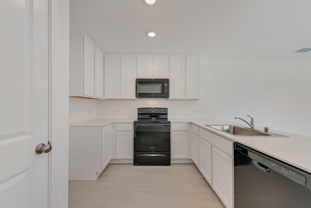 245 Boxberry Way Princeton, TX 75407 - Photo 12 of 23 a kitchen with a sink and a stove top oven