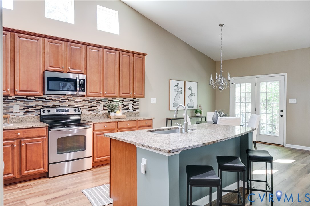 7538 South Franklins Way Quinton, VA 23141 - Photo 17 of 48 a kitchen with granite countertop wooden cabinets dining table stainless steel appliances and a window
