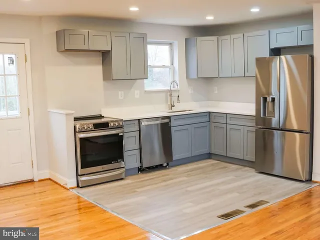 a kitchen with stainless steel appliances granite countertop a stove top oven and refrigerator