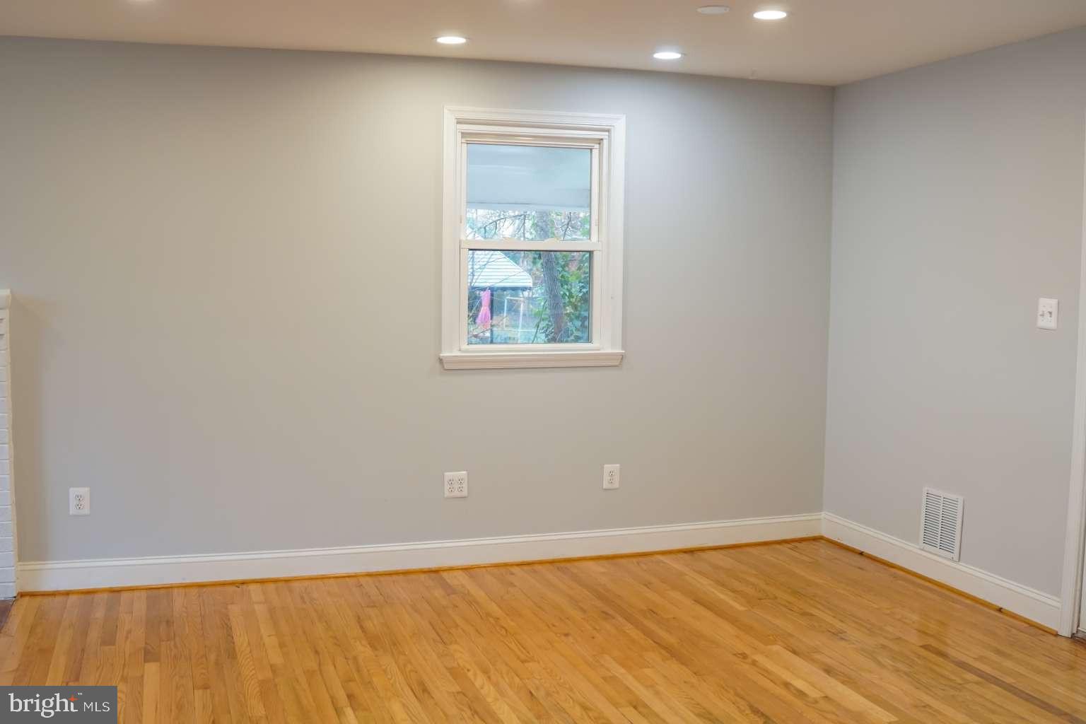 7107 Loch Raven Road Temple Hills, MD 20748 - Photo 9 of 36 an empty room with wooden floor and windows