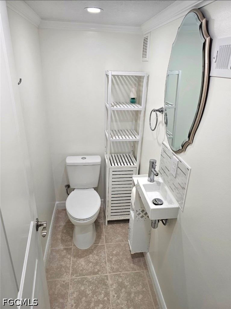 1130 Patterson Road Cape Coral, FL 33909 - Photo 11 of 21 a white toilet sitting next to a bathroom sink