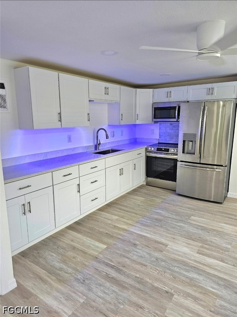 1130 Patterson Road Cape Coral, FL 33909 - Photo 16 of 21 a kitchen with cabinets and wooden floor