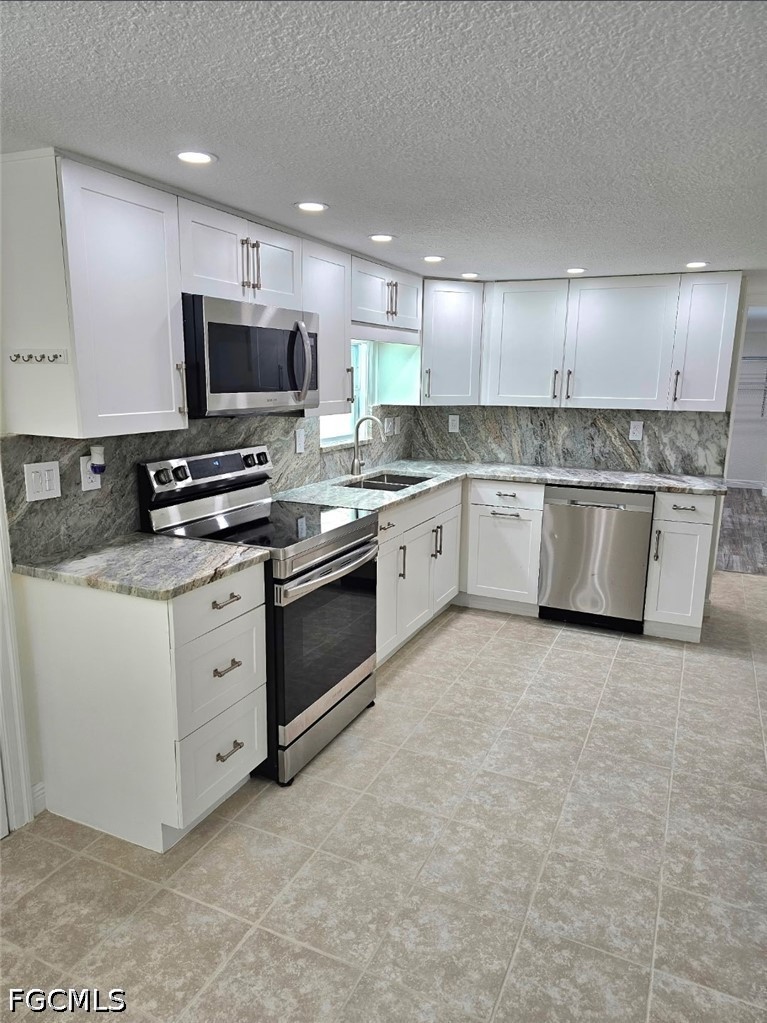 1130 Patterson Road Cape Coral, FL 33909 - Photo 3 of 21 a kitchen with stainless steel appliances granite countertop a stove top oven a sink dishwasher and a refrigerator