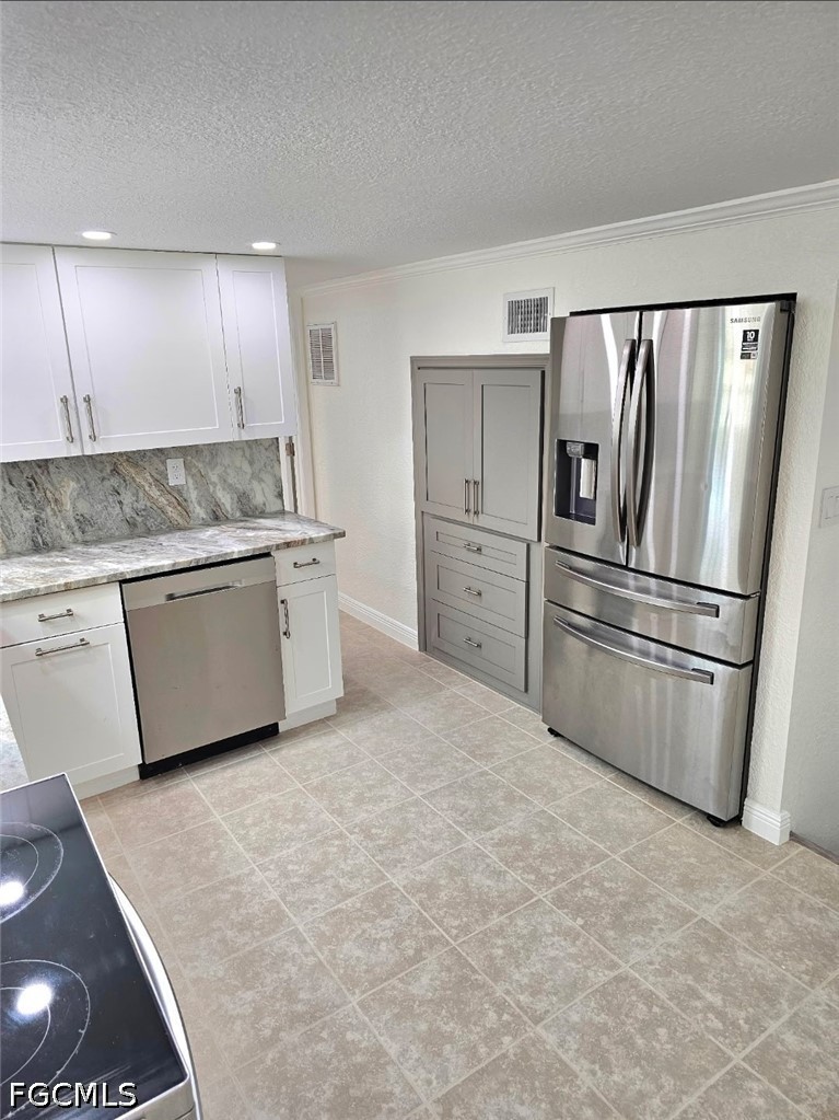 1130 Patterson Road Cape Coral, FL 33909 - Photo 4 of 21 a kitchen with stainless steel appliances granite countertop a refrigerator a sink and a stove