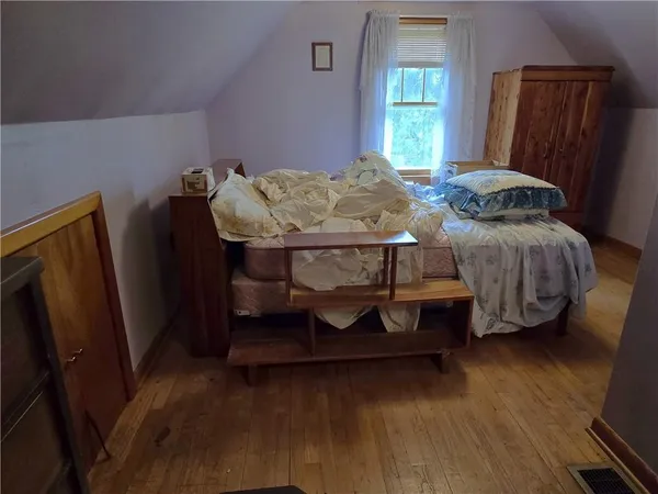 a bedroom with a bed chair and a window