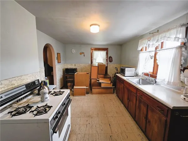 a large kitchen with kitchen island a stove a sink a dining table and chairs
