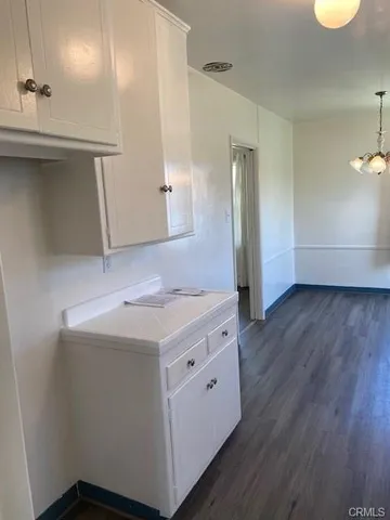 a kitchen with a wooden floor and cabinets
