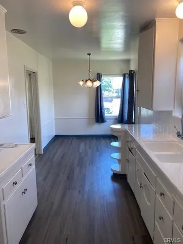 a kitchen with a hard wood floor counter top space and a sink