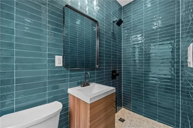 a bathroom with a sink a toilet and shower