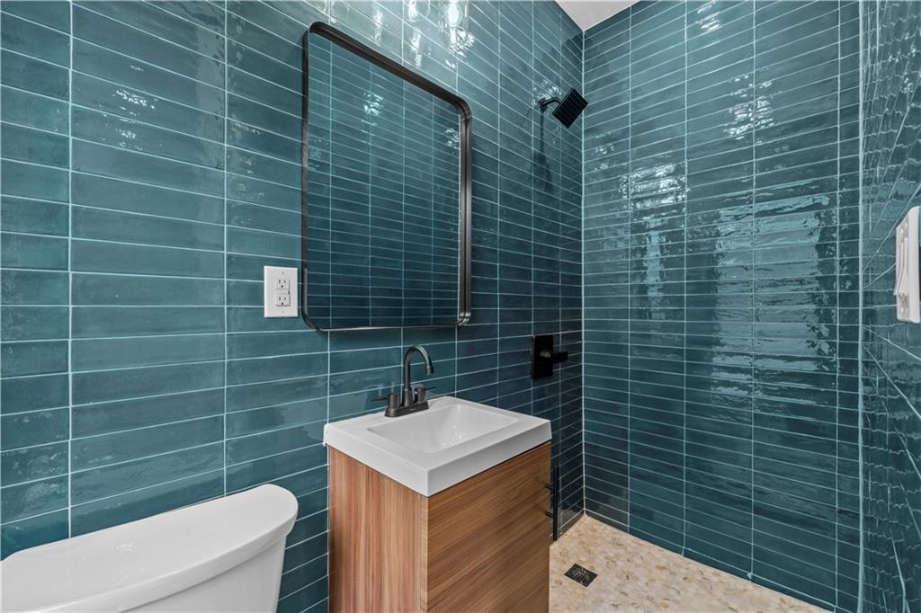 371 Grant Avenue Brooklyn, NY 11208 - Photo 12 of 19 a bathroom with a sink a toilet and shower