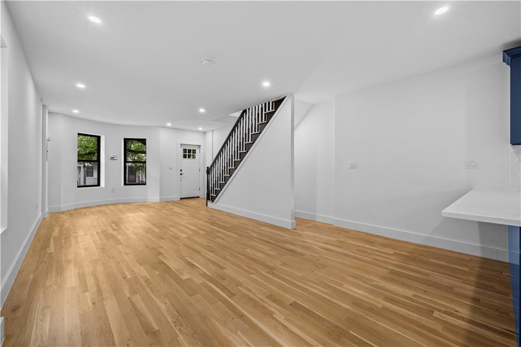 371 Grant Avenue Brooklyn, NY 11208 - Photo 5 of 19 a view of an empty room with wooden floor and stairs