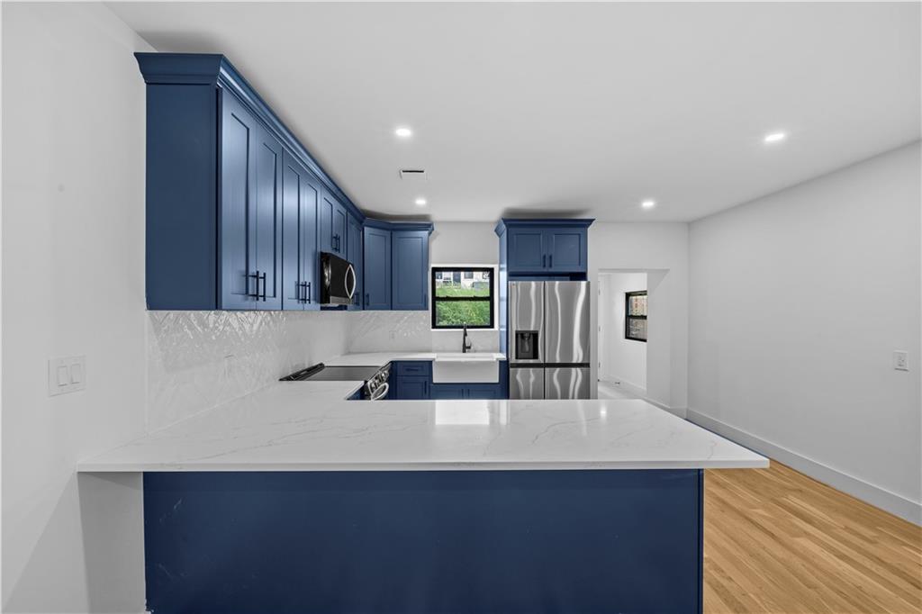 371 Grant Avenue Brooklyn, NY 11208 - Photo 6 of 19 a kitchen with stainless steel appliances a sink a microwave a refrigerator and wooden cabinets