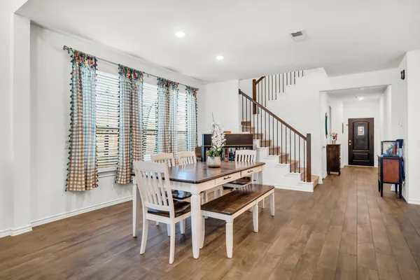 a dining room with furniture and wooden floor