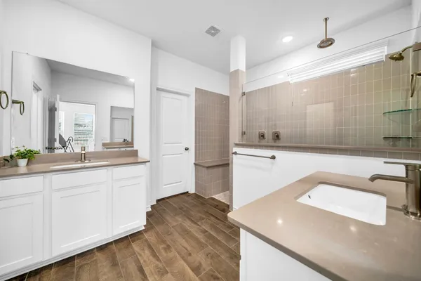 a spacious bathroom with a sink a shower and a mirror