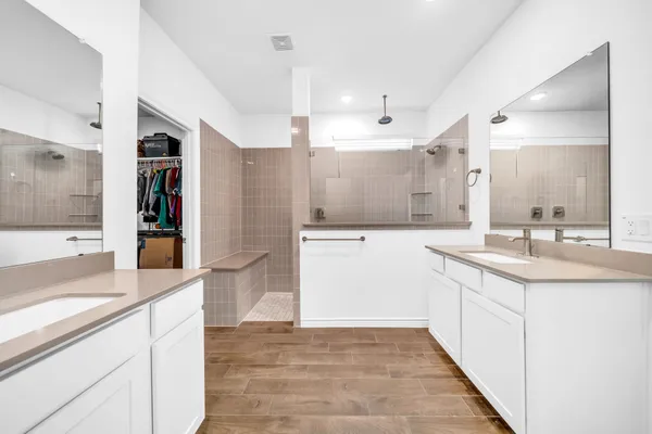 a large white kitchen with a sink and dishwasher with a large window