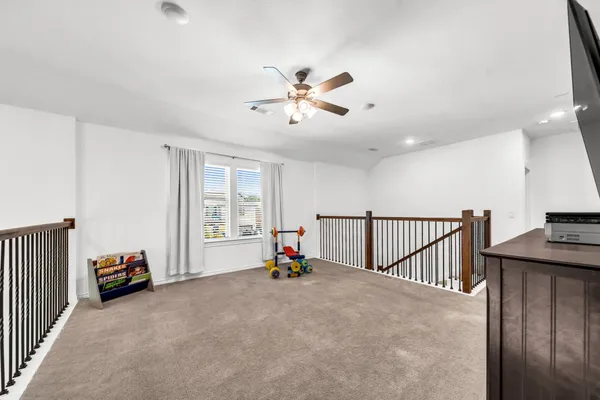 a living room with furniture and a ceiling fan