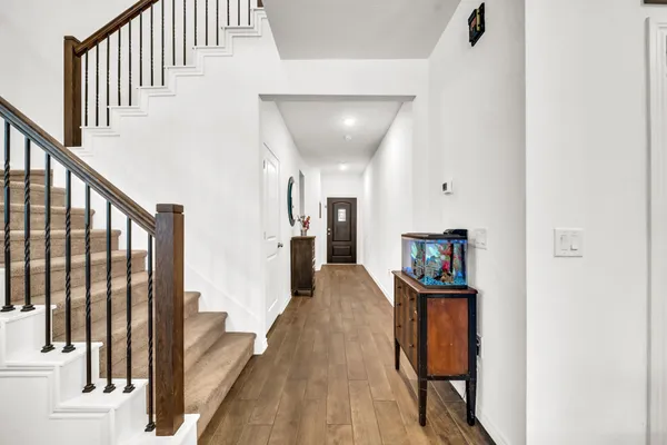 a view of a hallway with wooden floor and staircase