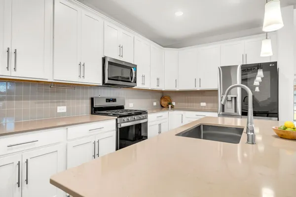 a kitchen with granite countertop a sink and white appliances